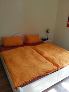 a bed with orange pillows and an orange blanket at Bernkastler Graben in Bernkastel-Kues