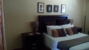 モコパネにあるPhokela Guest Houseのベッドルーム1室(ベッド1台、ランプ付きテーブル付)