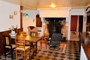 ein Wohnzimmer mit einem Tisch, Stühlen und einem Kamin in der Unterkunft Chez Nous in Isches