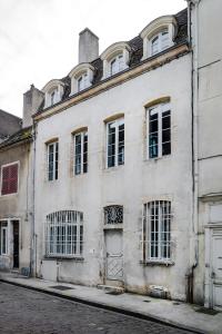 an old white building on the side of a street at La Maison Blanche in Beaune