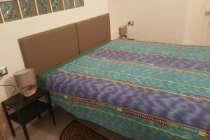 Schlafzimmer mit einem großen Bett mit blauer Decke in der Unterkunft Appartamento Martino in Genua