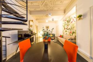 a living room with a table and orange chairs at RétroMirabeau - CHAMBRE Suite & APPARTEMENTS de Charme - Localisation Prémium in Narbonne