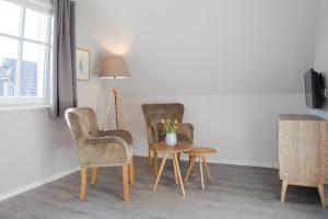 a room with two chairs and a table and a lamp at Haus Sommerliebe in Prerow