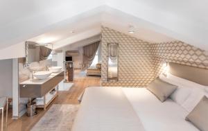 a bedroom with a large white bed and a bathroom at Villa Birdie Boutique - Adults Only in Donostia-San Sebastián