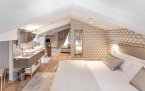 1 dormitorio con 1 cama blanca grande y baño en Villa Birdie Boutique - Adults Only, en San Sebastián