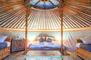 een slaapkamer met een hemelbed in een yurt bij Domaine EcÔtelia in Le Nizan