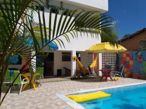 嘎林海斯港的住宿－Pedacinho do Céu，一座带椅子和遮阳伞的游泳池的房子