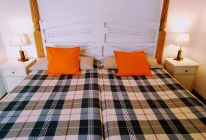 sypialnia z łóżkiem z pomarańczowymi poduszkami w obiekcie Barceloneta Ramblas Apartments w Barcelonie