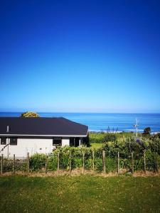 Seaview Cottage في Mokau: منزل أبيض مع المحيط في الخلفية +12 صورة