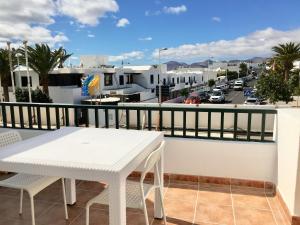 a white table on a balcony with a view of a city at Apt BARLOVENTO. Near the beach in Tías