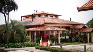 a large red building with a roof at Hotel Fazenda Itáytyba in Tibagi