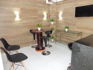eine Bar mit schwarzen Stühlen und einem Tisch in einem Zimmer in der Unterkunft Casa Praia dos Carneiros in Tamandaré
