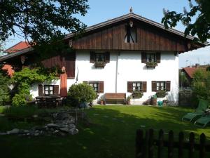 uma casa branca com um telhado de madeira em Beim Dokterer, Fewo ANNO DAZUMAL em Halblech