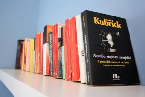 a row of books sitting on a shelf at B&B Verdegiada in Brindisi