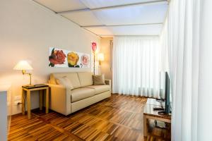 a living room with a couch and a television at Juvarrahouse Luxury Apartments in Turin