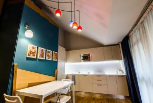 Juvarrahouse Luxury Apartments في تورينو: مطبخ بطاولة بيضاء وحائط ازرق