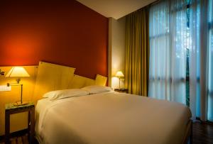a bedroom with a large white bed and a window at Juvarrahouse Luxury Apartments in Turin