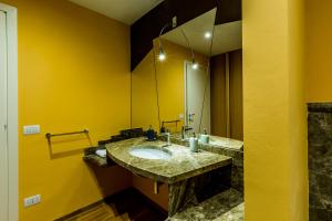 a yellow bathroom with a sink and a mirror at Juvarrahouse Luxury Apartments in Turin +13 photos