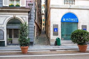 une rue avec deux plantes en pot devant un bâtiment dans l'établissement Triangolo D'oro, à Gênes