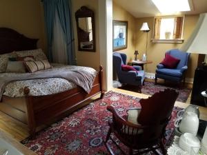 a bedroom with a bed and two chairs and a rug at Lilly Pad in Cedarburg