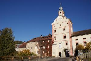 Un edificio con una torre con un orologio sopra di Hotel Gasthof Prunner a Gmünd in Kärnten