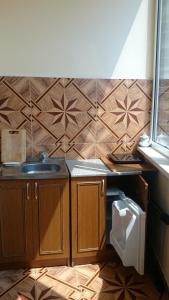アドレルにあるApartments na Kirovaのタイル張りの壁、洗面台付きのバスルーム