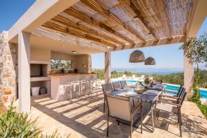 an outdoor kitchen and dining room with a table and chairs at Hacienda Noa in Grohote