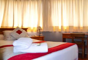 um quarto de hotel com uma cama com toalhas em Hotel Dikran em Los Ángeles