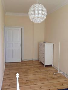 a room with a chandelier and a dresser and a room with at Magnificent turn of century flat (legal) in Berlin