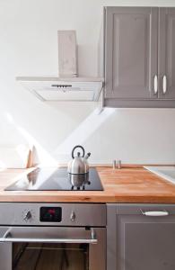 a tea kettle sitting on top of a stove in a kitchen at Magnificent turn of century flat (legal) in Berlin +8 photos