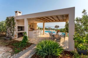 eine Terrasse eines Hauses mit einem Tisch und Stühlen in der Unterkunft Hacienda Noa in Grohote