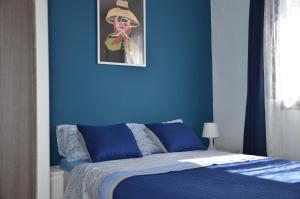 een blauwe slaapkamer met een bed met een blauwe muur bij Casa de la playa in Punta de Mujeres