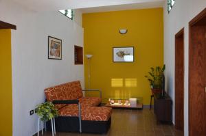 a living room with a chair and a yellow wall at Casa de la playa in Punta de Mujeres