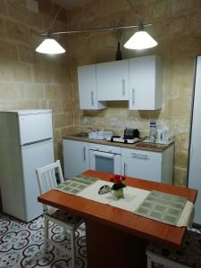 a kitchen with white cabinets and a wooden table with a table sidx sidx at Sixty Two #4 in Victoria