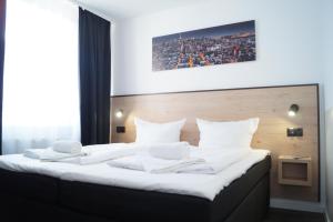 a bedroom with a large bed with white sheets at Hannover-City-Pension in Hannover