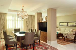 a dining room and living room with a chandelier at Miramar By Windsor Copacabana in Rio de Janeiro