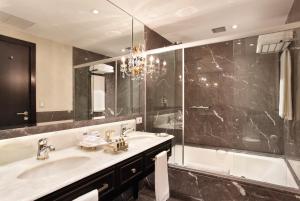 a bathroom with a sink and a tub and a mirror at Miramar By Windsor Copacabana in Rio de Janeiro