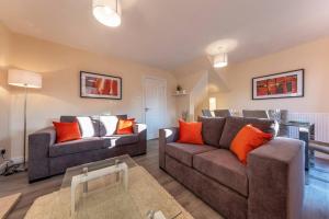 a living room with two couches and orange pillows at Cheshire House - In The Heart Of Cheshire - FREE Parking - Working Professionals, Contractors, Families - Winsford in Winsford