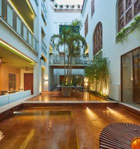 a courtyard of a building with a table and chairs at Hotel Boutique Casona del Colegio in Cartagena de Indias