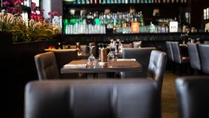 a restaurant with a table and chairs and a bar at Royal Amsterdam Hotel in Amsterdam