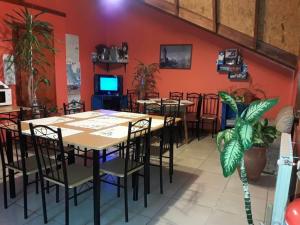 a dining room with tables and chairs and a tv at Mirador del Beagle Hosteria in Ushuaia