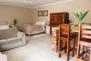 Bietjie Rus في أدو: غرفة معيشة مع سرير وأريكة