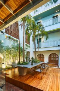 um pátio com uma mesa, cadeiras e palmeiras em Hotel Boutique Casona del Colegio em Cartagena de Indias