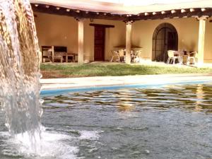 a water fountain in front of a house at Finca Las Pircas Casa de Adobe in Famatina