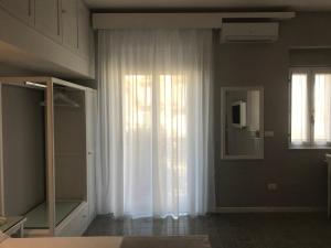 a room with a window with white curtains and a mirror at Residenza Corallina in Tropea +28 photos