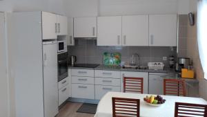 a kitchen with white cabinets and a table with a bowl of fruit at StaynFeel 01 in Fátima