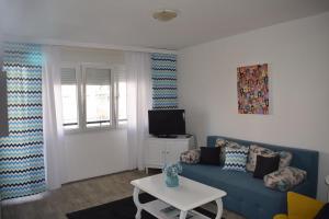 a living room with a blue couch and a tv at Apartment Optimist/Downtown in Split