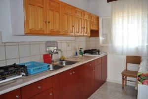 a kitchen with wooden cabinets and a sink at Sea View Bungalows in Skala Kallirachis