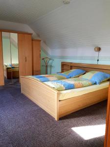a bedroom with a wooden bed with blue pillows at Ferienhaus Nannen in Rechtsupweg