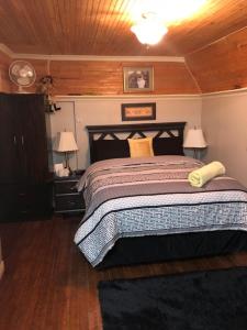 a bedroom with a bed and a wooden ceiling at By The Sea Tourist Home in Bonavista